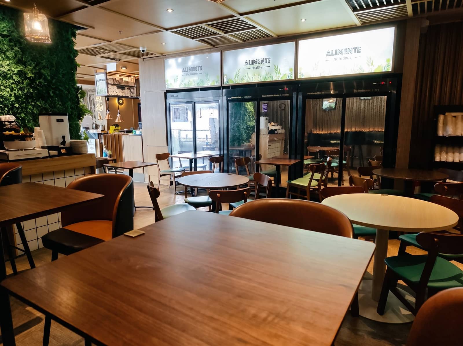 Alimente 堂食區望向 Wholesome、Healthy、Nutritious 品牌燈箱與綠色植物牆
